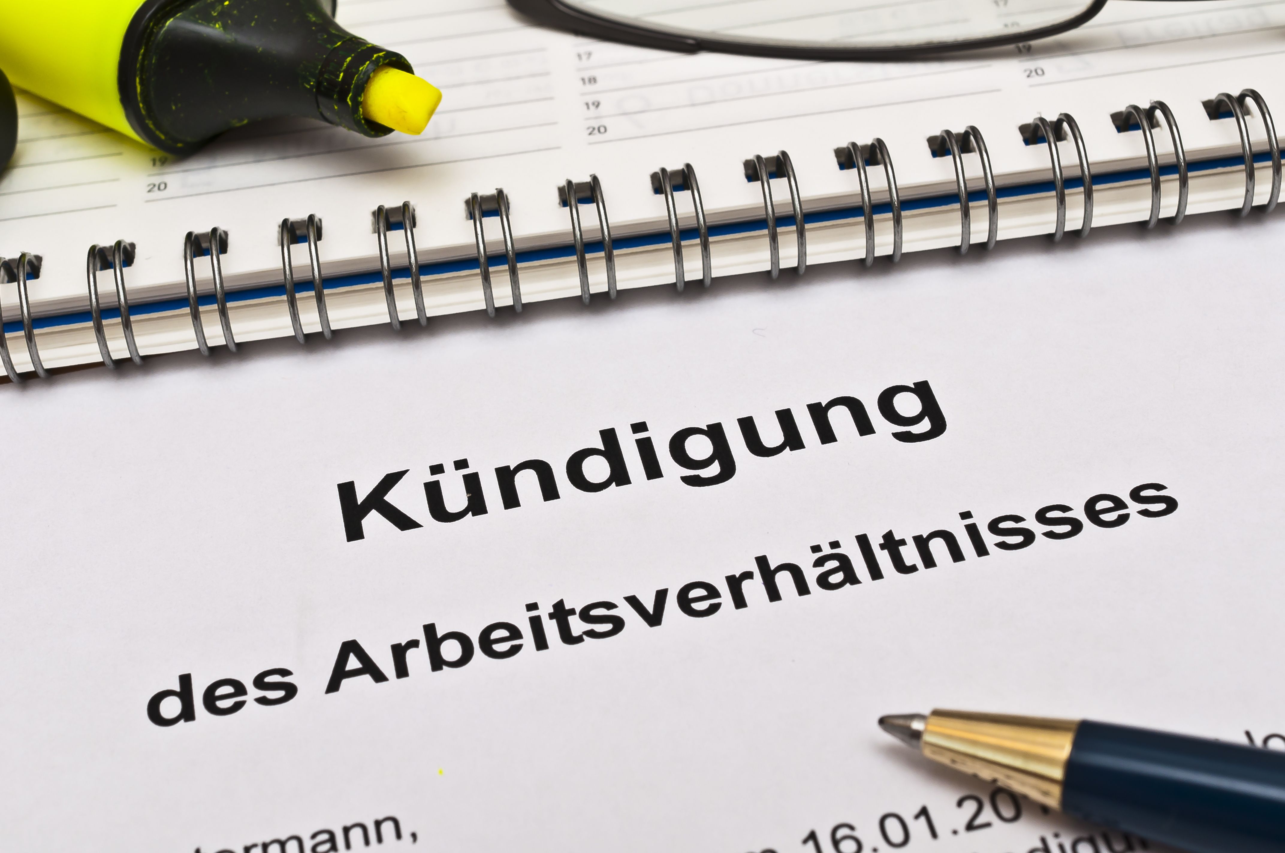 Kündigung des Arbeitsverhältnisses neben Kalender, Textmarker und Kugelschreiber