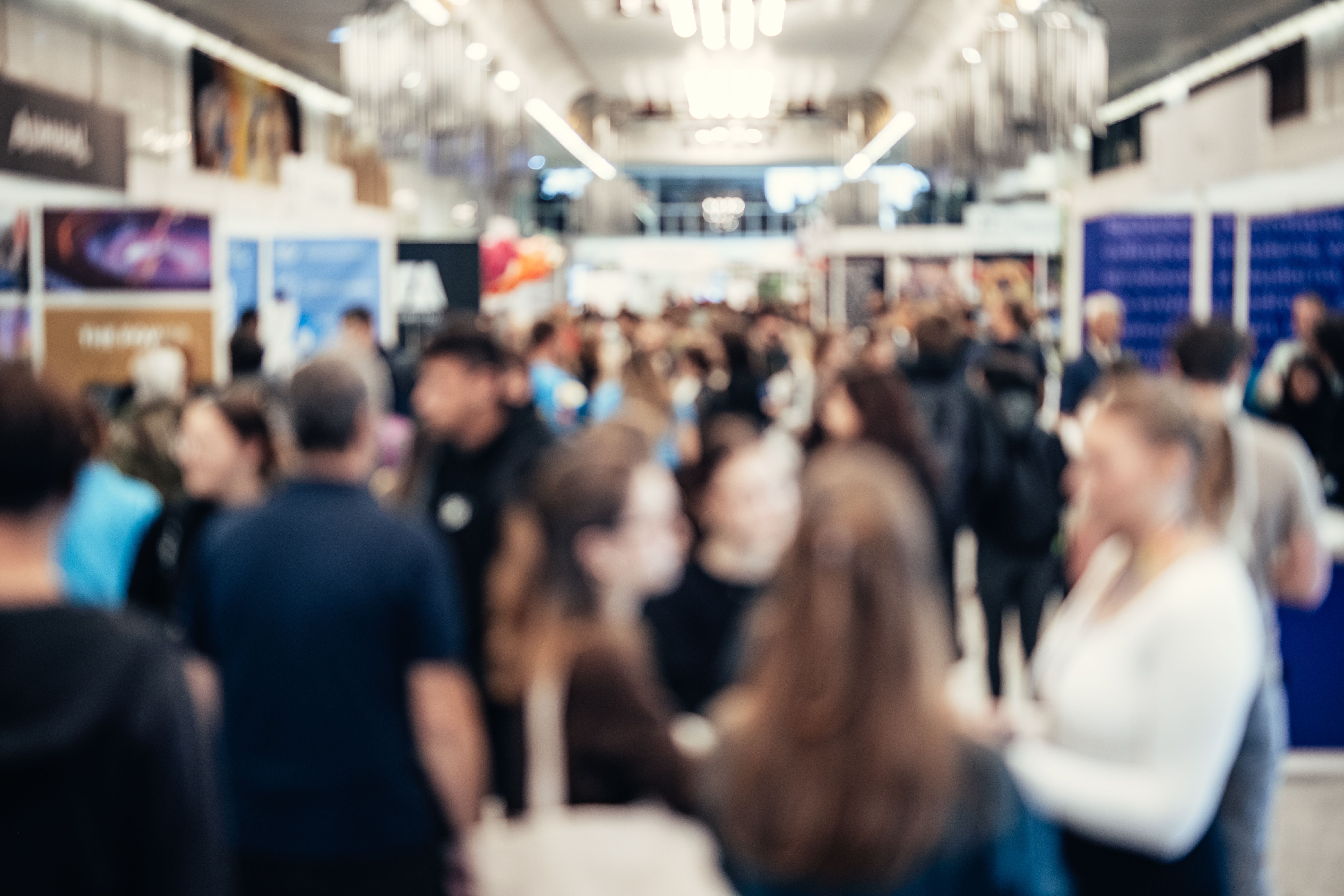 Besucherinnen und Besucher auf einer gut besuchten Jobmesse in Halle (Saale) informieren sich an den Messeständen über Jobs und Karrieremöglichkeiten.