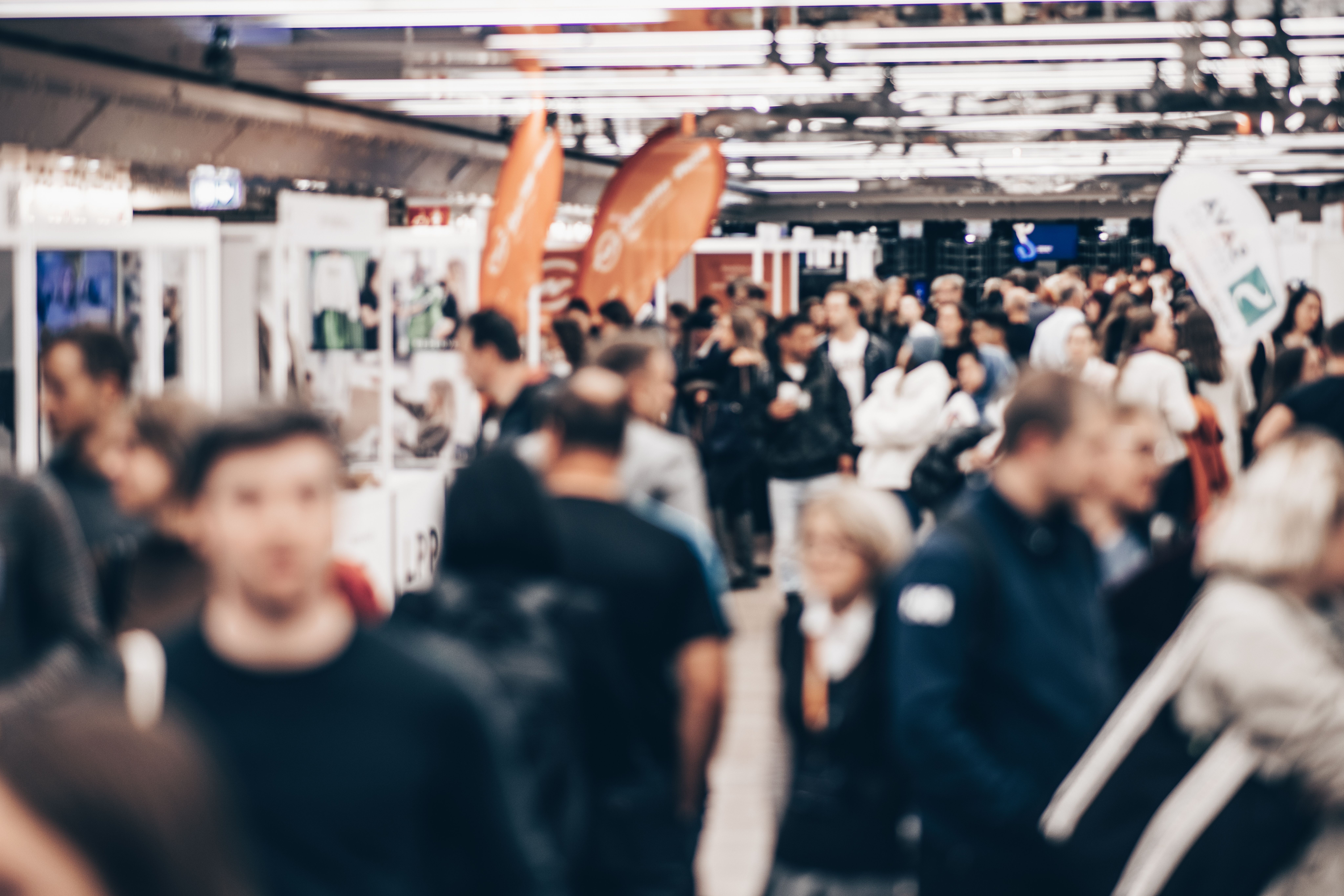 Besucherinnen und Besucher auf einer gut besuchten Jobmesse in Braunschweig im Gespräch mit Unternehmen und Recruitern an Messeständen