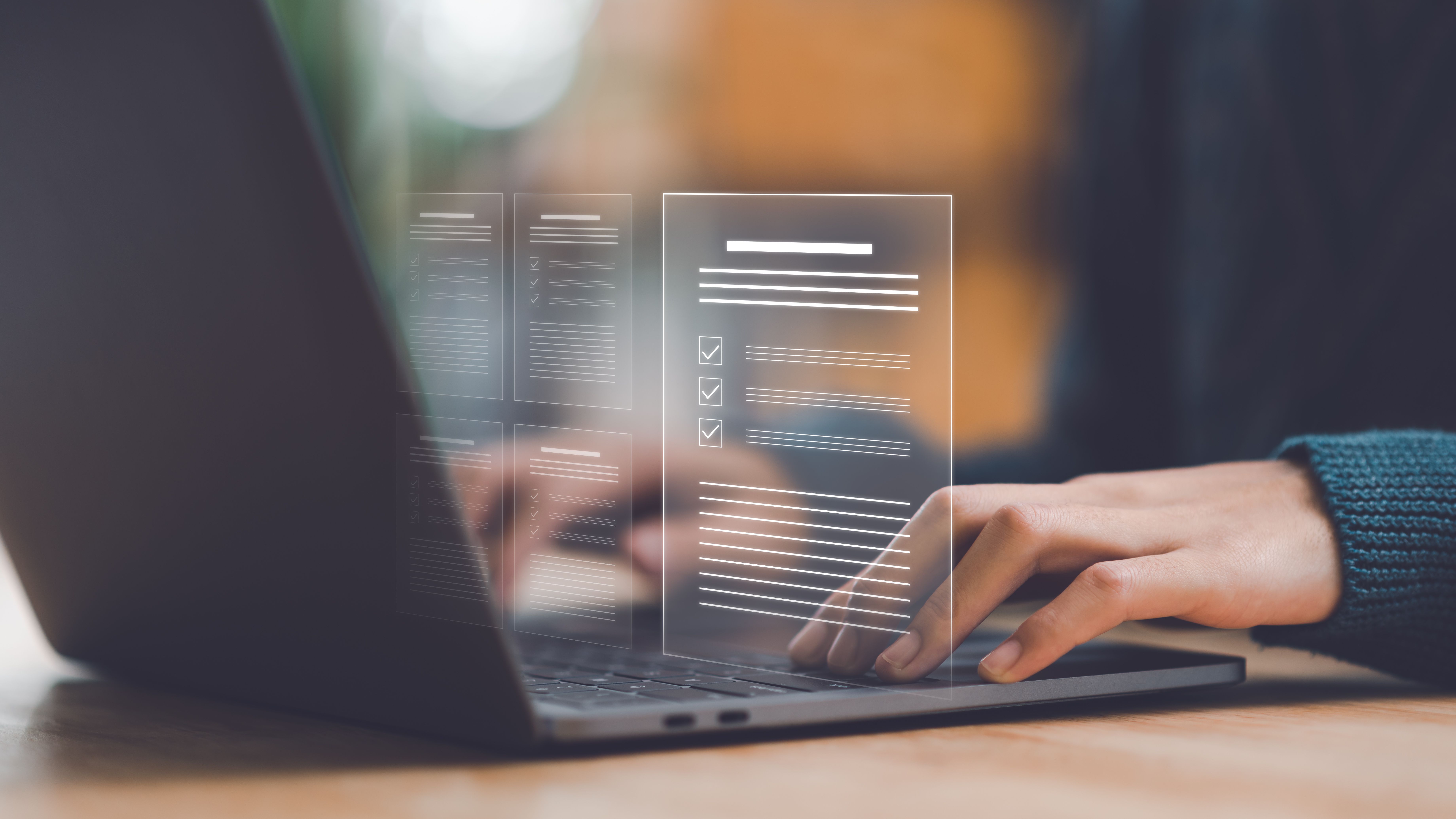 Person erstellt ein digitales Bewerbungsschreiben am Laptop mit virtuellen Dokumenten für eine professionelle Online-Bewerbung