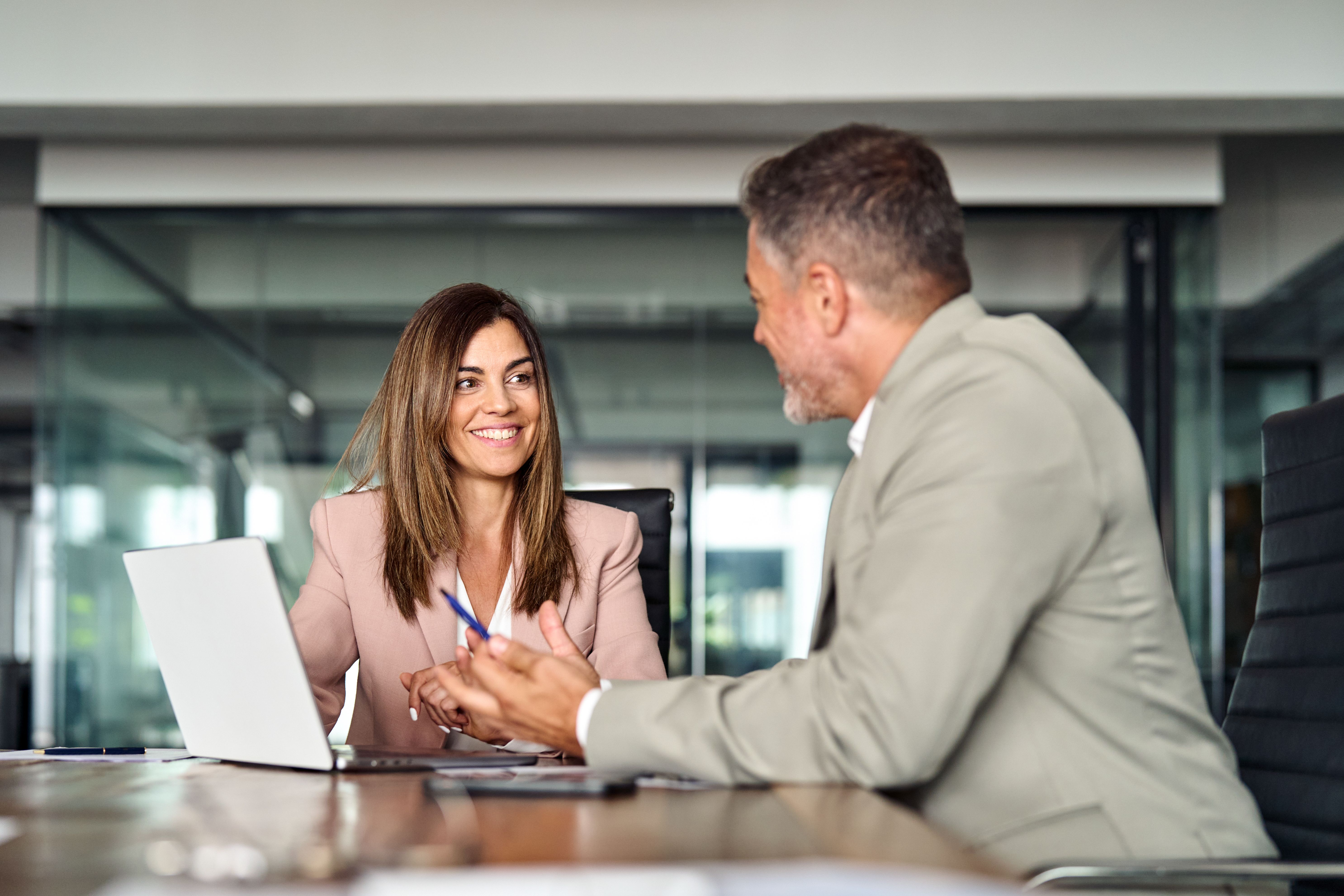 Vorstellungsgespräch zwischen Bewerberin und Personaler in einem modernen Besprechungsraum während eines persönlichen Jobinterviews.