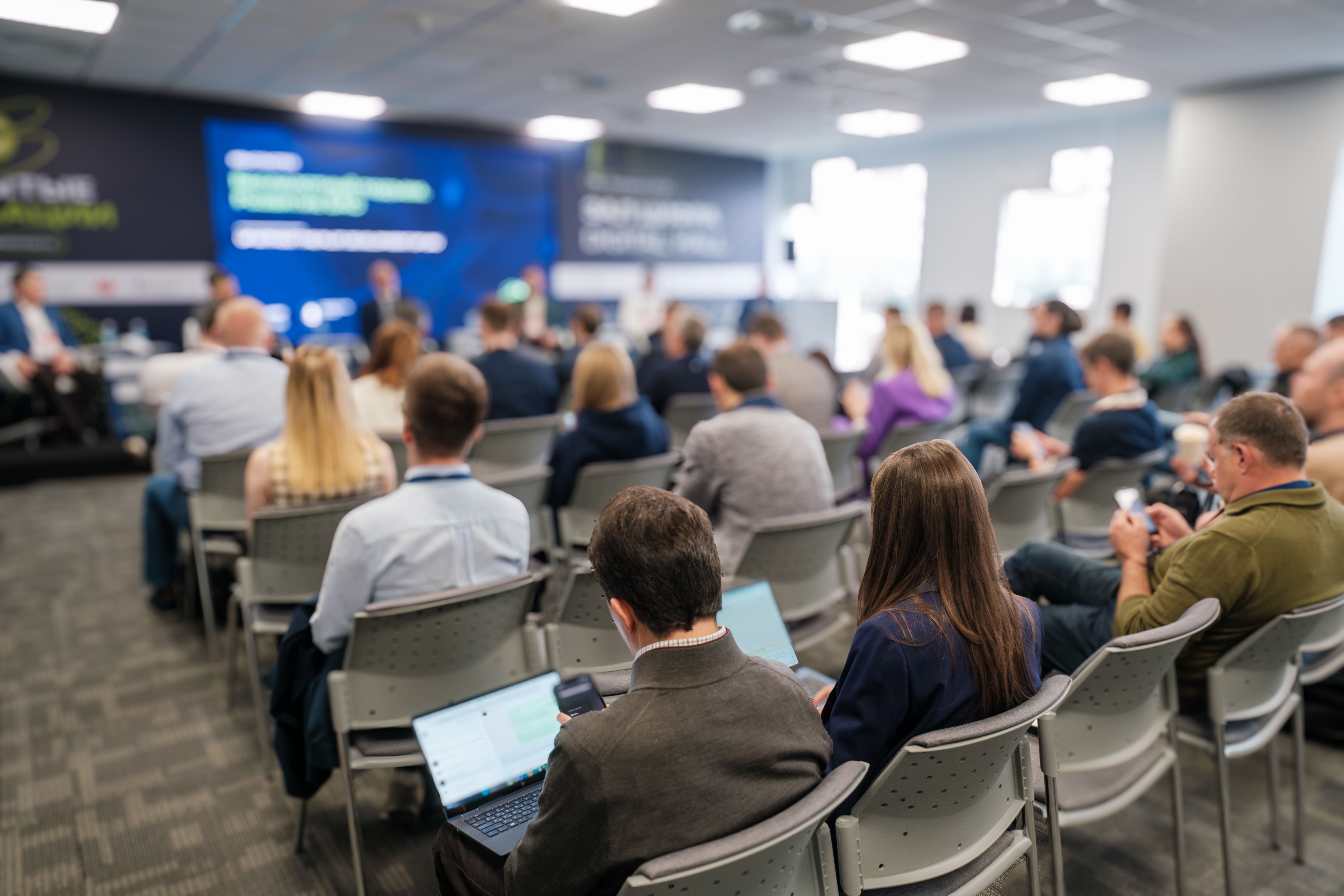Teilnehmerinnen und Teilnehmer bei einer Karriereveranstaltung mit Fachvorträgen, Networking und Unternehmenspräsentationen in einer modernen Konferenzumgebung