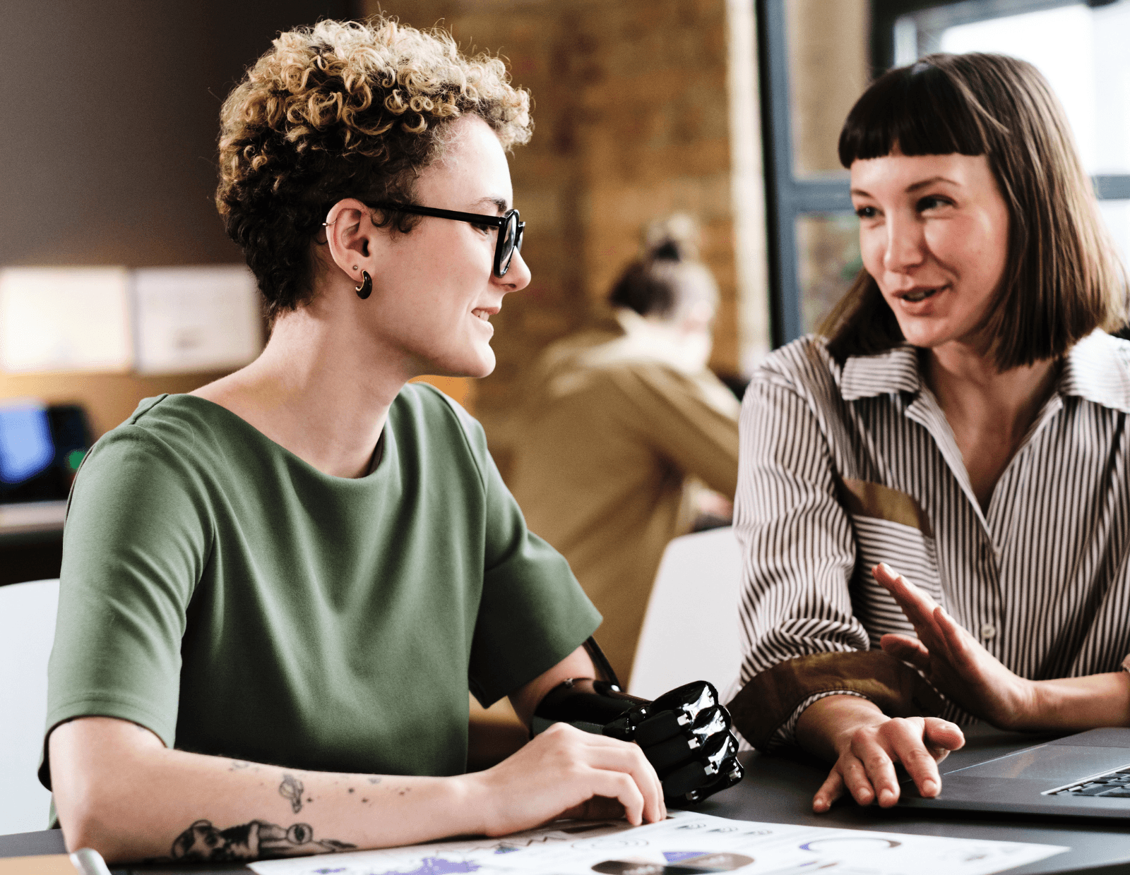 Mitarbeiterin mit einer Handprothese arbeitet gemeinsam mit Kolleginnen und Kollegen in einem modernen und inklusiven Büro.